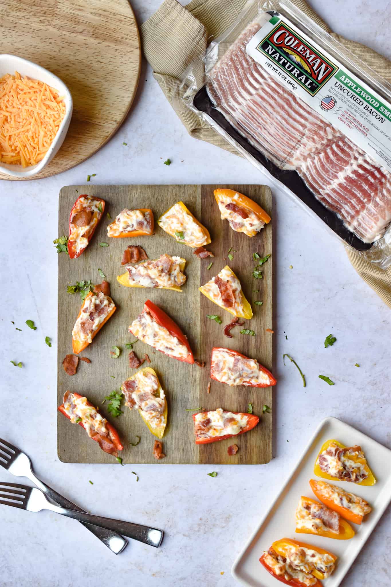Two plates of bacon stuffed mini peppers are in the frame.