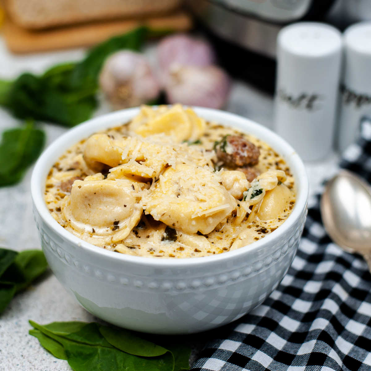 Bowl of creamy soup with tortellini, sausage and spinach ready to eat.
