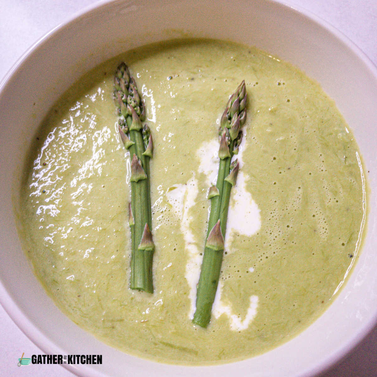 Top down view of a bowl of creamy asparagus soup.