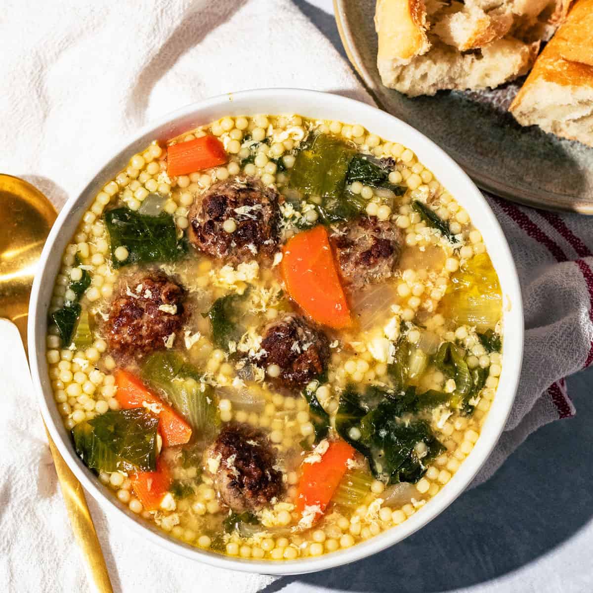 Italian wedding soup with a side of crusty bread.