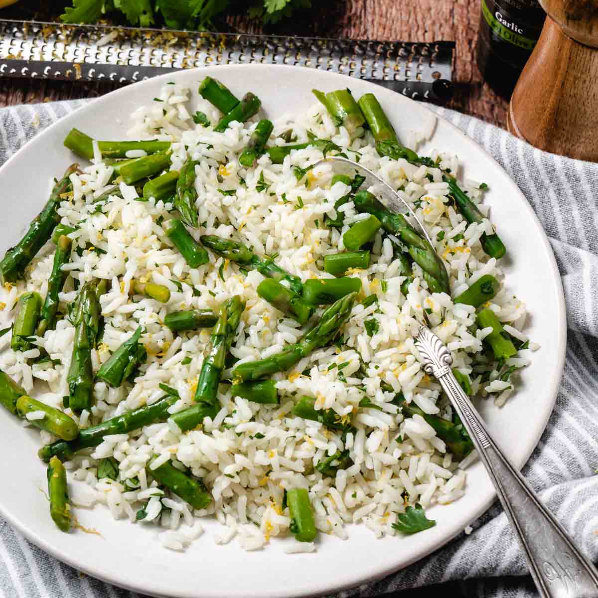 Rce with asparagus in a bowl with a spoon.