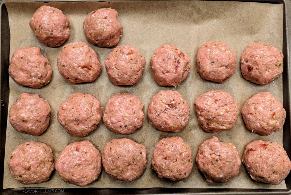 Baked Sun-Dried Tomato Turkey Meatballs on a sheet pan before they've baked.