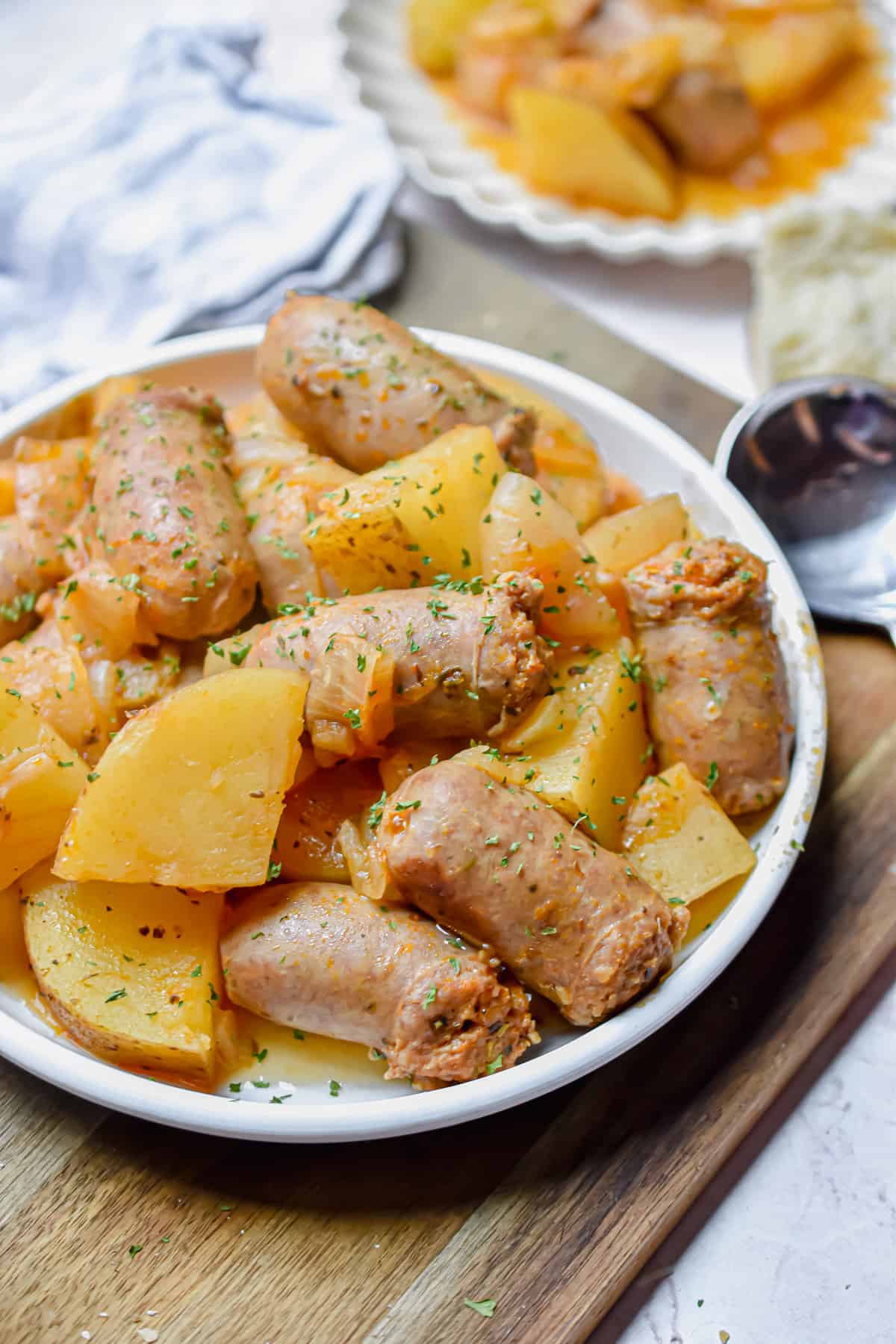 The Instant Pot Sausage and Potatoes are on a plate on a cutting board.
