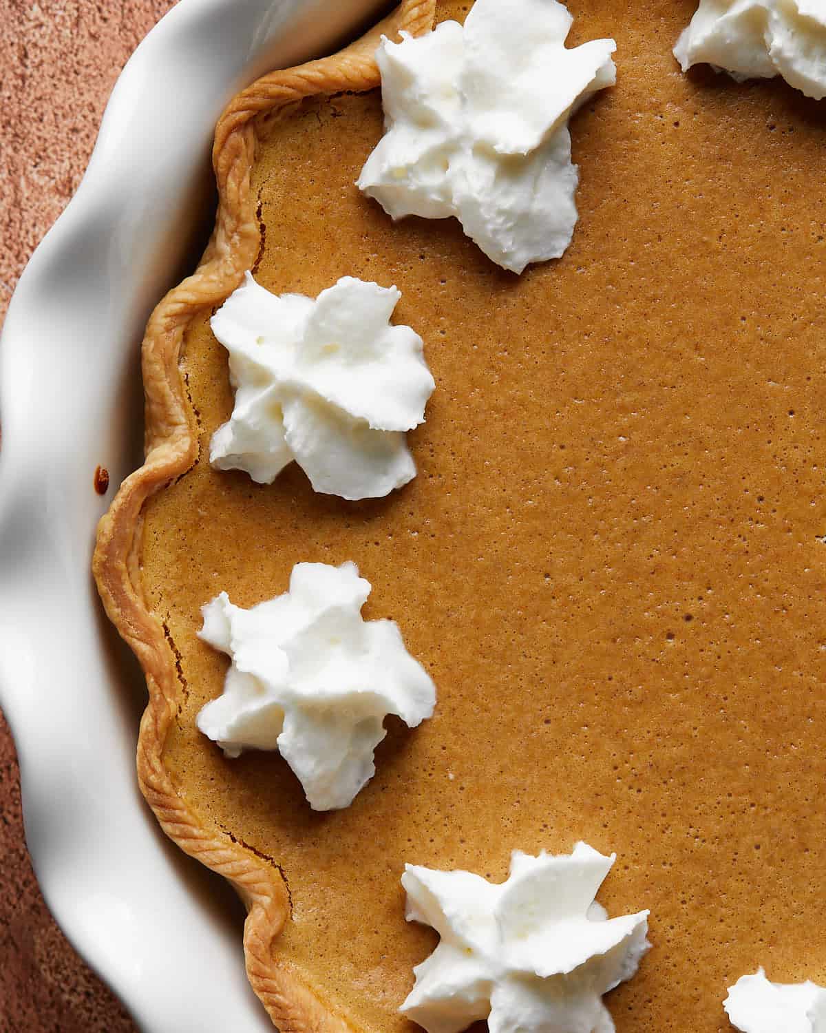 Slice of cream cheese pumpkin pie on a plate.